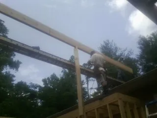 Carpenter setting a ridge beam over a new addition frame — Ice Dam Removal by Roofing Brothers in Blackstone