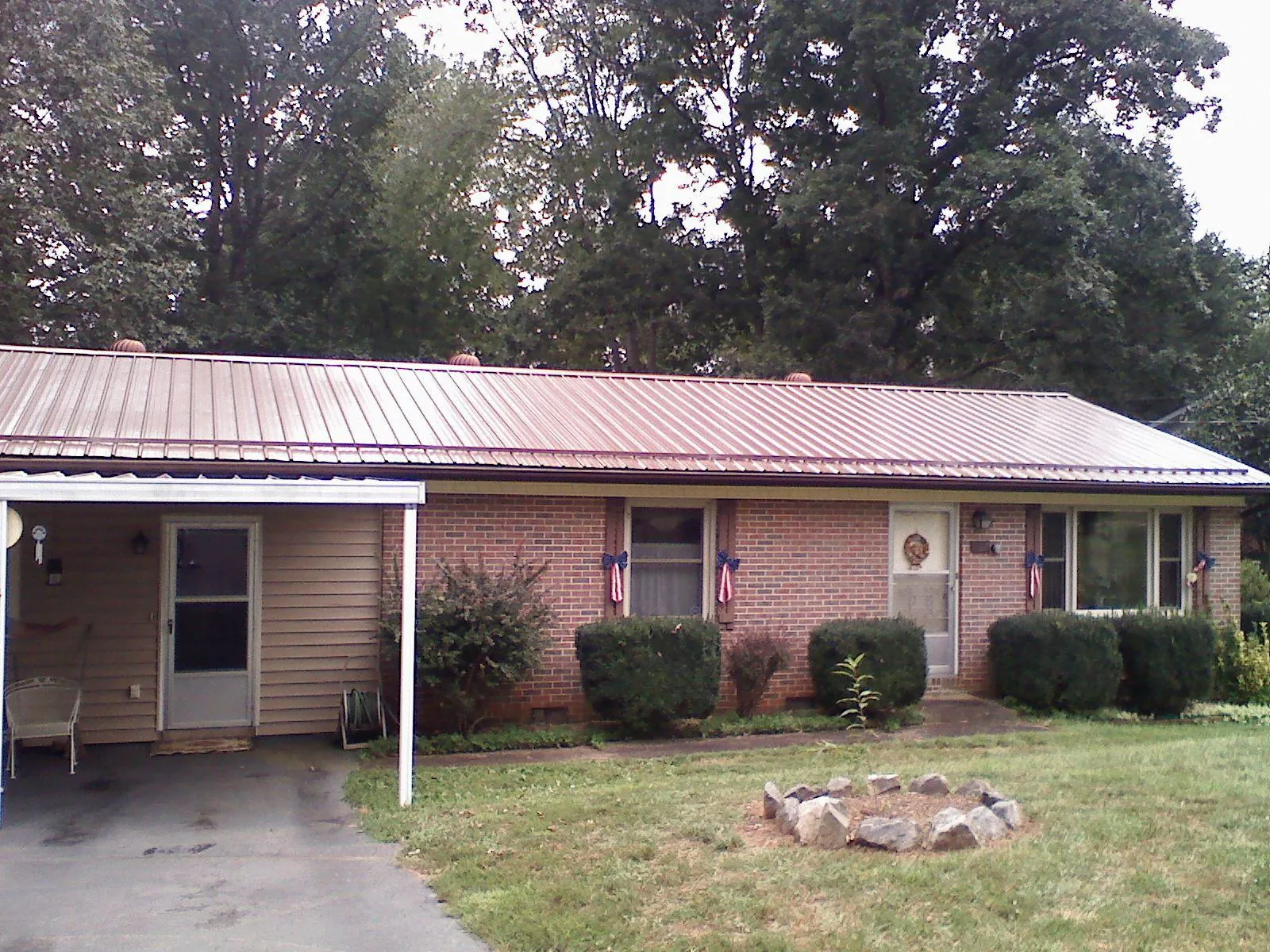 Bronze metal roof and carport on a brick ranch home — Roof Repair work by our crew in Blackstone